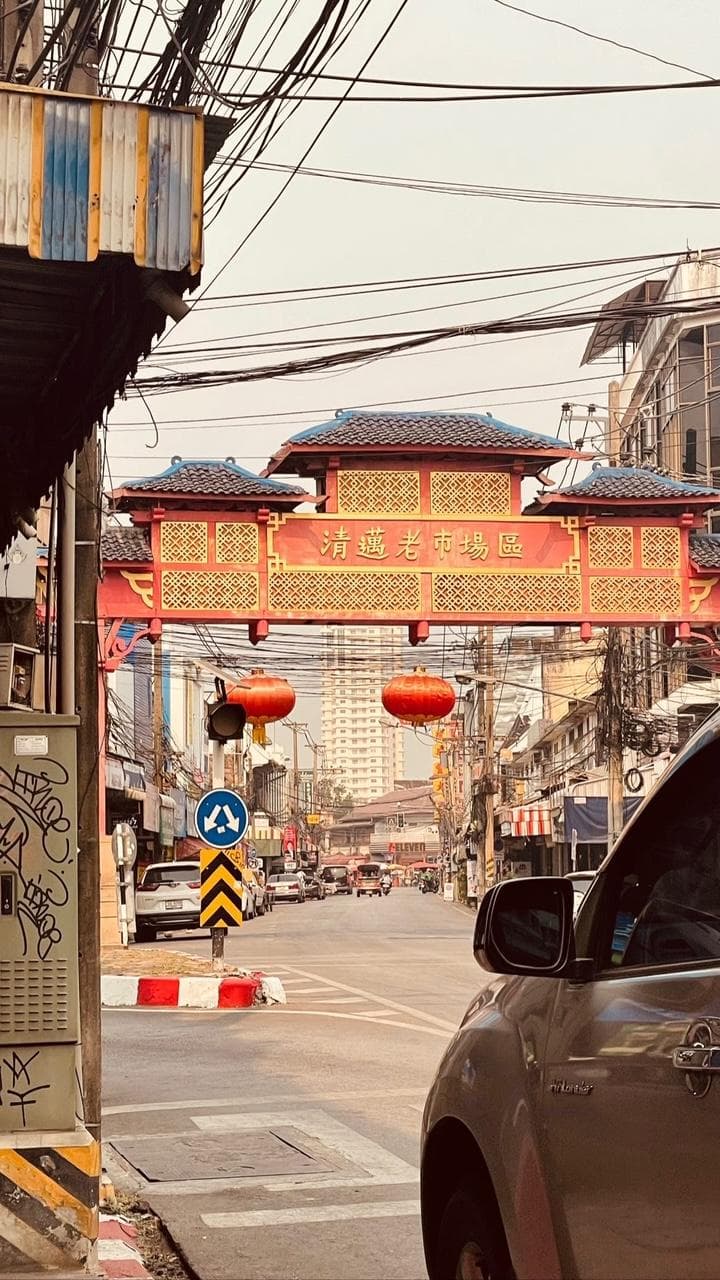 The red and gold gate to the Chiang Mai old market district, red lanterns strung beneath it.